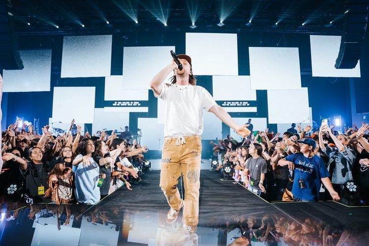 Artist walking the stage front with the crowd reaching in