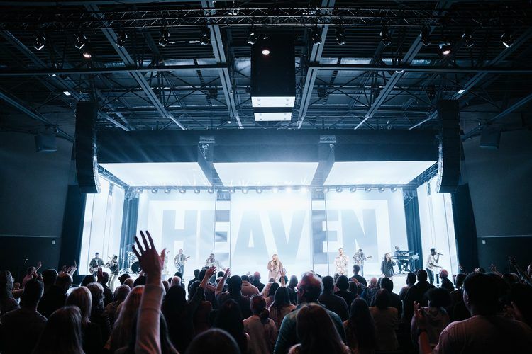 Conference stage with the word Heaven across the screen