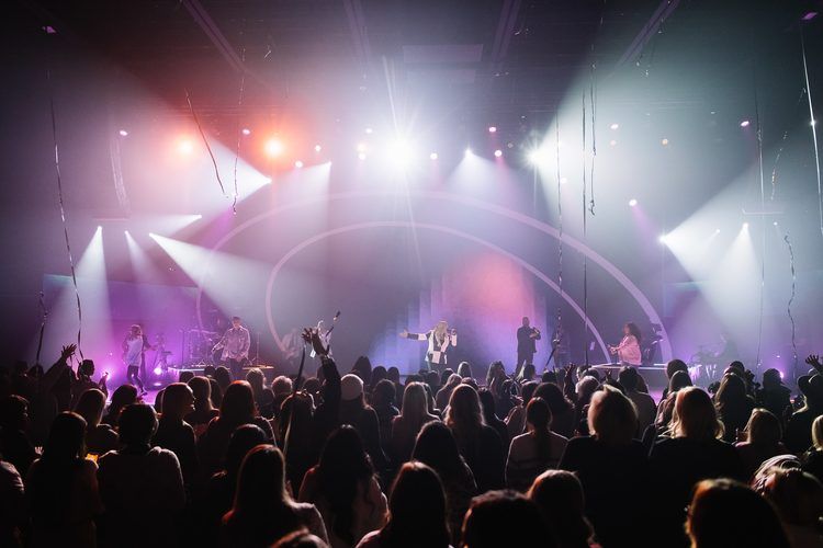 Beams crossing over a standing crowd in magenta and white