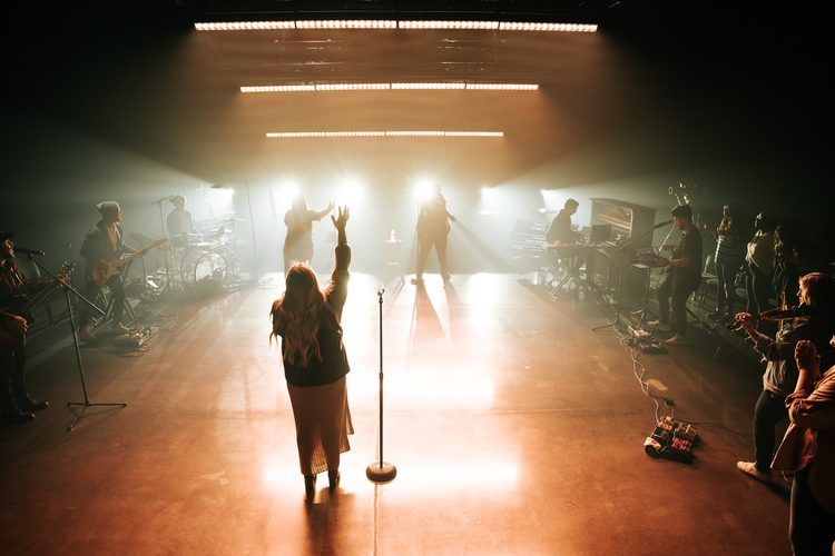 Backlit worship moment in warm haze