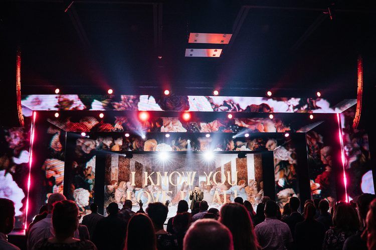 Full band under a red and white cross-lit rig